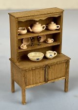Cabinet with dishes, pottery, and brass goblets