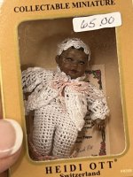 (image for) Black baby in white crocheted pants, sweater, and hat